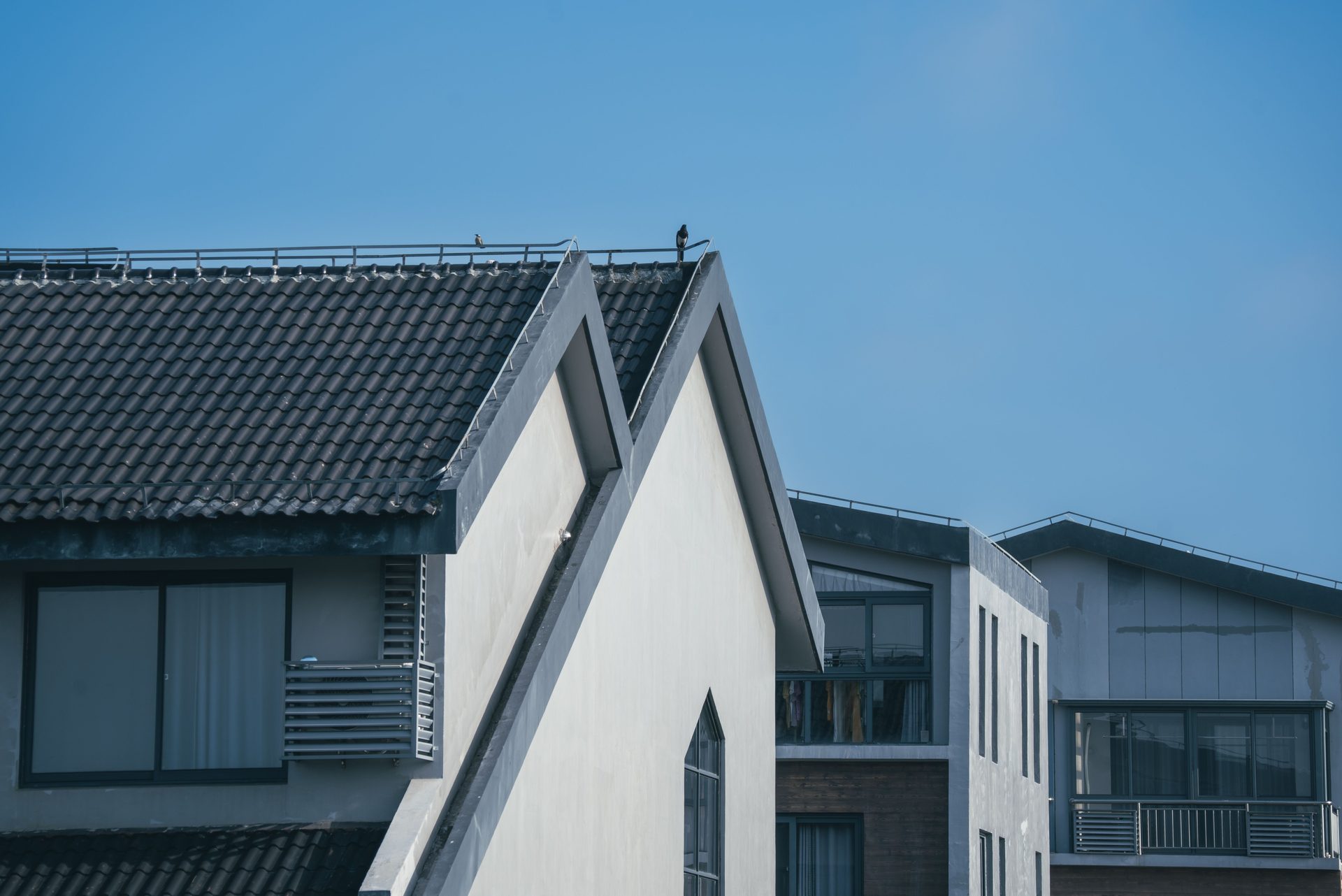 Modern home with clean, attractive rooflines against a bright blue sky — roofing contractor serving Hampton Roads, VA